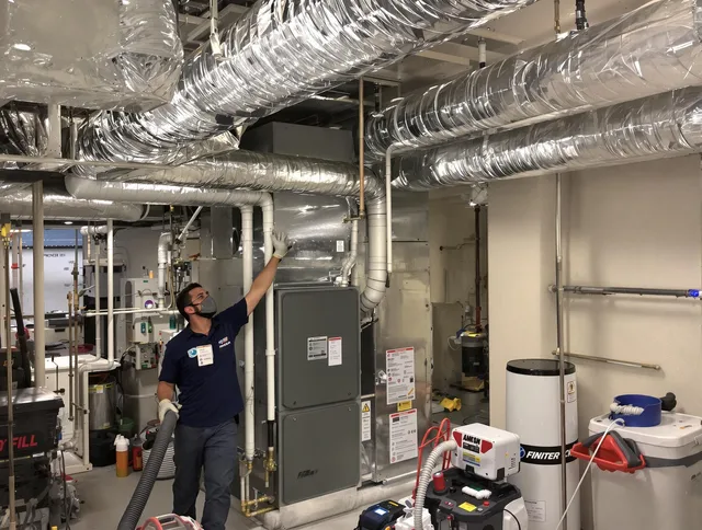 Duxbury Air Duct Cleaning specialist performing thorough furnace duct cleaning in a Duxbury residence